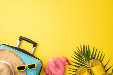 Colorful summer-themed arrangement featuring a suitcase, straw hat, sunglasses, and flip-flops on a...
