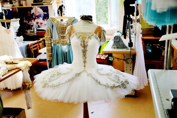 Beautiful white ballerina dress in the sewing workshop of the theater. The art of interior...