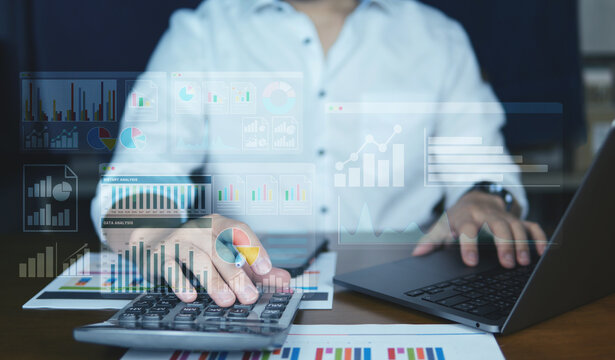 Close-up of hands working on a laptop with colorful virtual data dashboards overlay, showing charts, analytics, and KPI performance metrics. Modern workplace and technology concept.