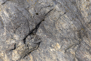 Natural rock surface featuring evident cracks and textured formations