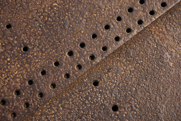 Detailed view of a rusty metallic surface featuring textured patterns