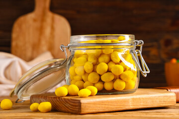 Jar with cheese coated peanuts on wooden background