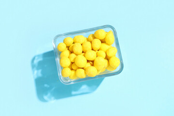Bowl with cheese coated peanuts on blue background