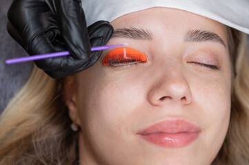 Caucasian woman undergoing eyelash lamination procedure. 