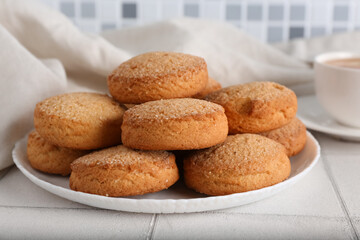 Plate with sweet cookies on white tile table