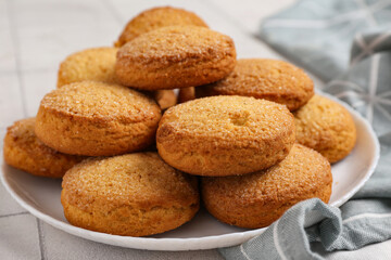 Plate with sweet cookies on white tile background, closeup