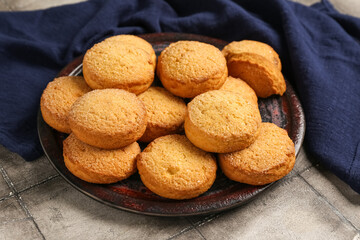 Plate with sweet cookies on grey tile background, closeup