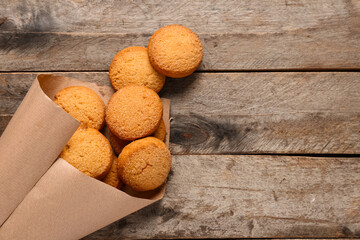Paper cone with sweet cookies on wooden background