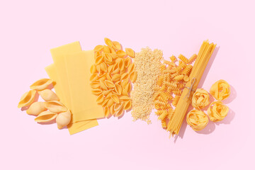 Composition with different types of raw tasty pasta on pink background