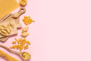 Composition with different types of raw tasty pasta and wooden cutting boards on pink background