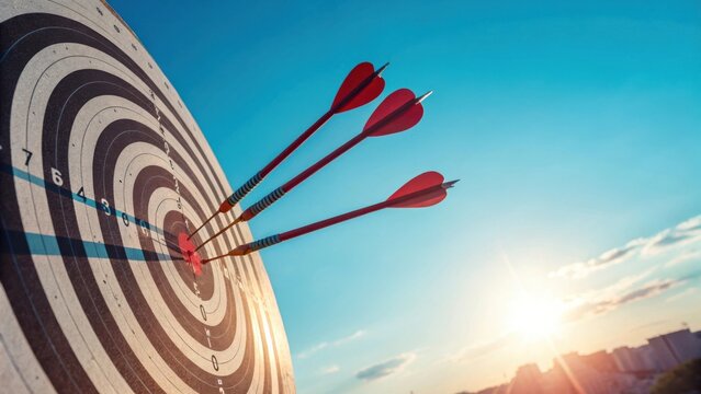 Three red arrows hit bullseye on dartboard against blue sky darts target