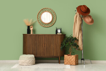 Interior of hallway with stylish hats, coat rack and commode