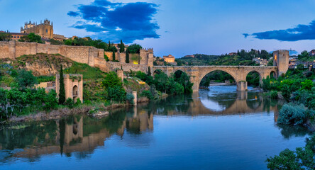 San martin bridge reflecting in tagus river at blue hour, toledo, spain