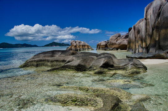 Granite boulders touching crystal-clear shallow water in the seychelles