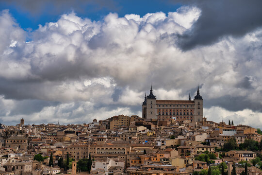 Alcazar of toledo dominating the cityscape under dramatic cloudy sky