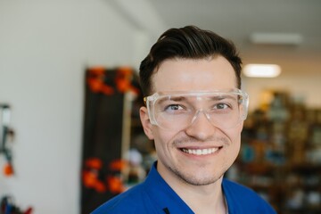 Portrait of smiling industrial worker wearing safety glasses in factory