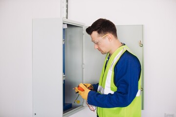 Electrician performing maintenance using multimeter on electrical panel