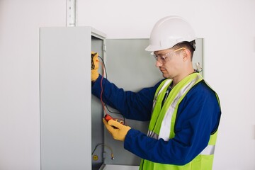 Electrician performing maintenance check using multimeter on electrical panel