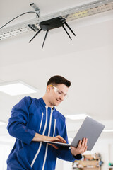 Technician configuring wireless router using laptop in modern office