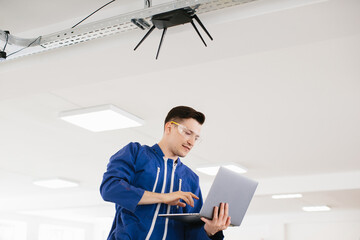 Technician configuring wireless router using laptop in office building