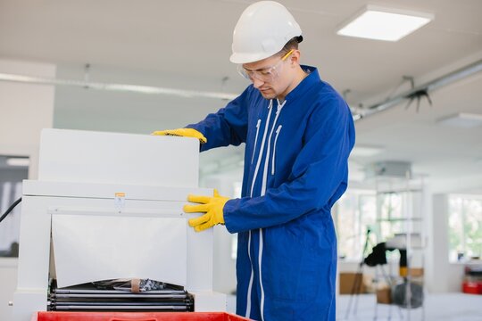 Technician operating industrial paper shredder in factory