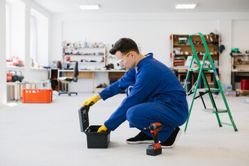 Handyman opening toolbox in workshop wearing protective glasses