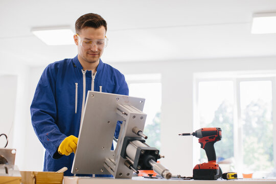 Engineer working on a hydraulic press machine in a factory