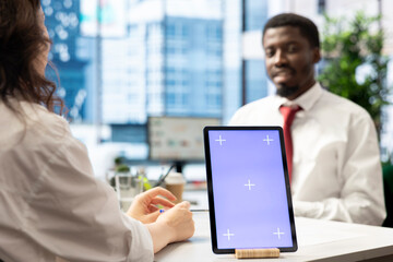 Recruiter using isolated screen tablet doing interview with person after finding best talent to fill open company position. HR department employee using mockup device, finalizing deal with man