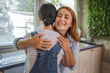 female friends hug each other in the kitchen at home
