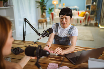 under the shoulder view of japanese host record podcast at home studio