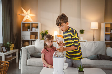 boy help to little girl to make pop corn use pop corn maker at home