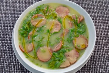 Traditional winter soup known as Portuguese green broth prepared good potatoes, kale and sausage. The best Portuguese broth in the world