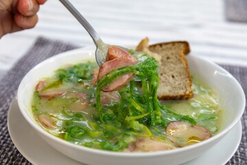 Traditional winter soup known as Portuguese green broth prepared good potatoes, kale and sausage. The best Portuguese broth in the world