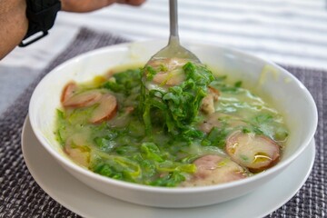 Traditional winter soup known as Portuguese green broth prepared good potatoes, kale and sausage. The best Portuguese broth in the world
