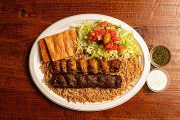 Lamb and chicken kofta on a plate with rice and salad
