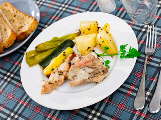 Rabbit meat prepared with potato, zucchini and green bell pepper.