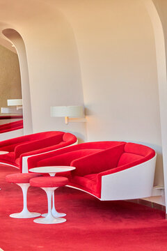 Red Mid-Century Armchairs and White Railings in Atrium
