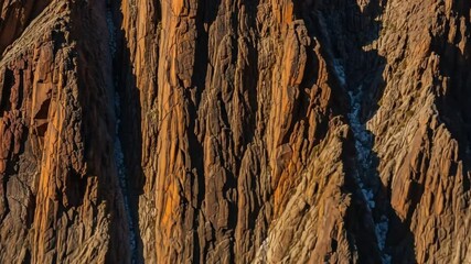 Detailed textured closeup of rugged rock cliff revealing natural earth tones and intricate - Powered by Adobe
