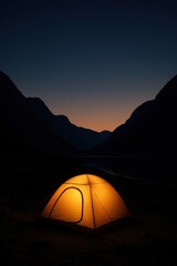 Glowing tent in tranquil mountain valley at dusk under starry sky