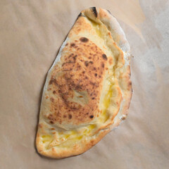 calzone con caciocavallo, mortadella e mozzarella su di un foglio di carta