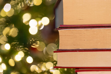  winter books. Books with red covers stack on Christmas tree background.Stack of Books with Bokeh...
