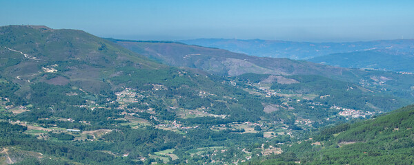 Mountain valley with forest and rural buildings