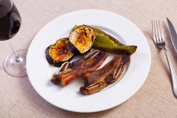 Nicely served plate of tasty brazilian barbecued steak with eggplants and chili peppers
