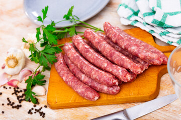 Fresh raw sausage (Longaniza) on kitchen board in restaurant