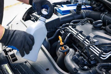 Worker checking motor oil level in car with dipstick, closeup