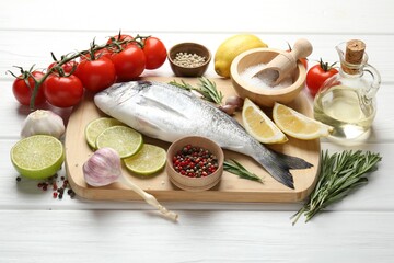 Fresh raw dourade with spices on white wooden table. Fish and seafood delicacies
