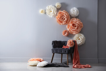 Photo zone with stylish floral decor and armchair in studio, space for text