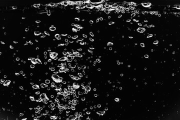 黒の背景に水中に舞い上がるたくさんの気泡.