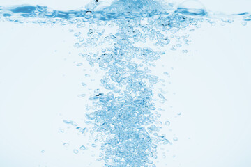 青の背景に水中に舞い上がるたくさんの気泡.