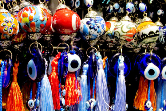 Traditional Turkish Nazar amulets used for protection. Nazar Boncugu Glass ornaments with circular patterns in blue, white, and black, displayed in rows. Close-up of blue evil eye protective amulet